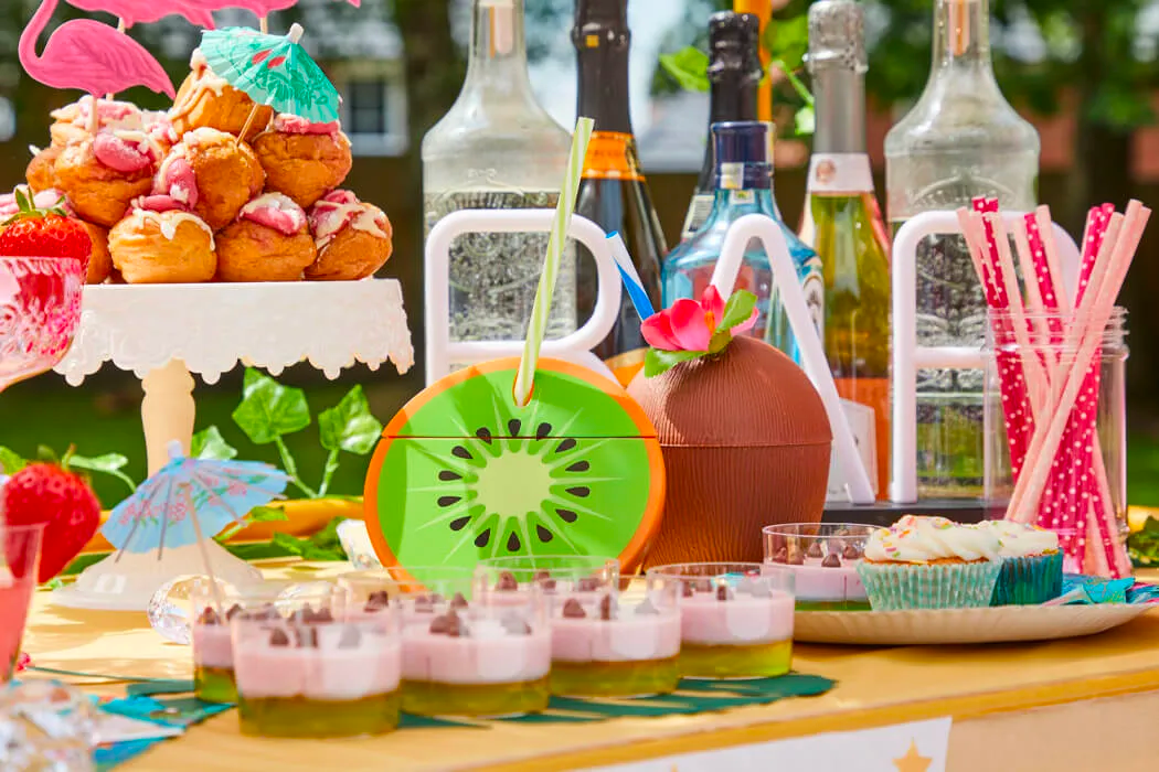 Summer party deserts on a table with drinks in the background