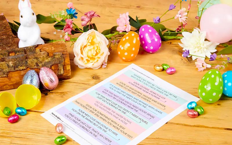 Printable outdoor Easter egg hunt clues printed out on a table with plastic eggs and sweets