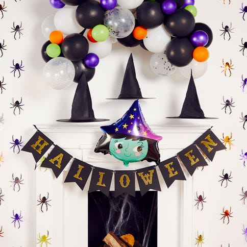 fireplace decorated with witch shaped balloon, floating witch hat and happy halloween bunting