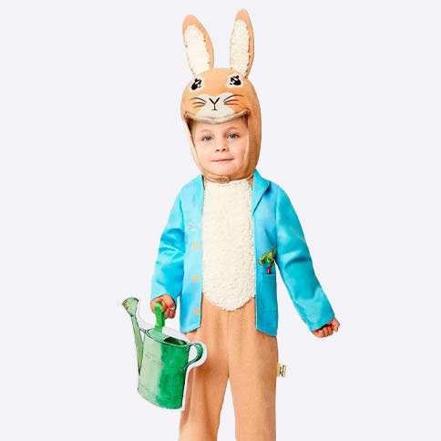 Toddler dressed in Peter Rabbit jumpsuit with green watering can