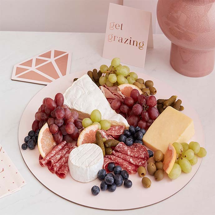ring shaped grazing board with cheese, grapes and cured meat