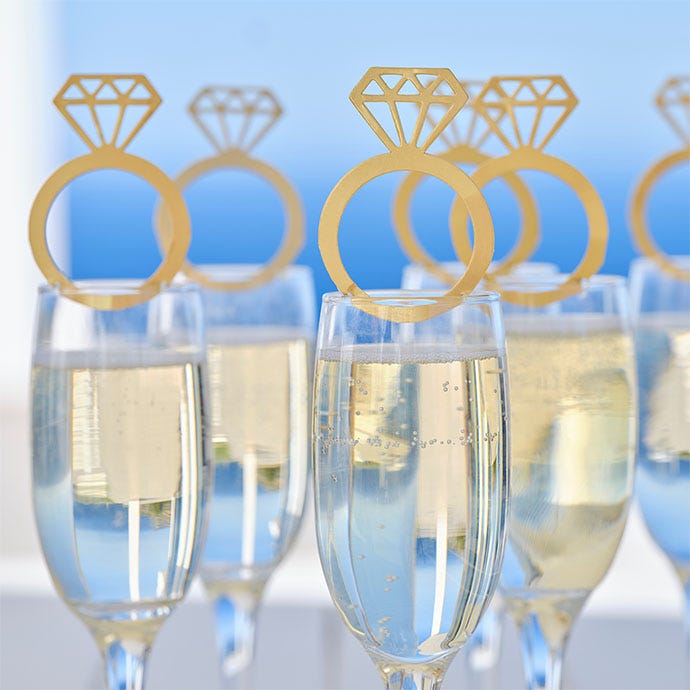 full champagne glasses with ring shaped glass toppers