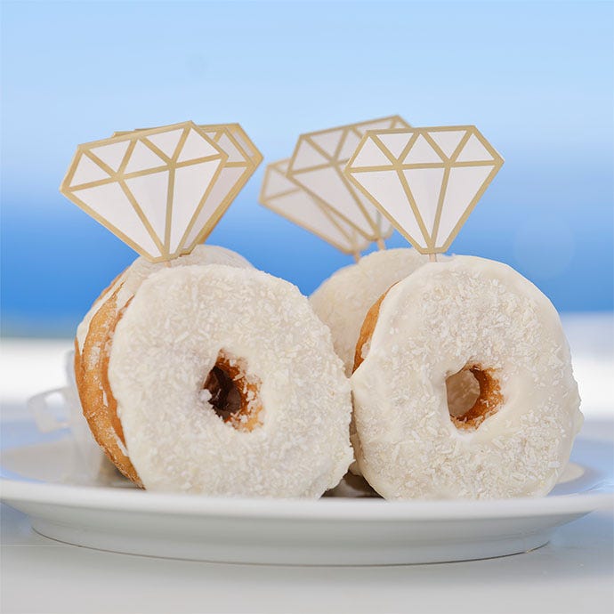ring donuts with white icing and diamond shaped paper toppers