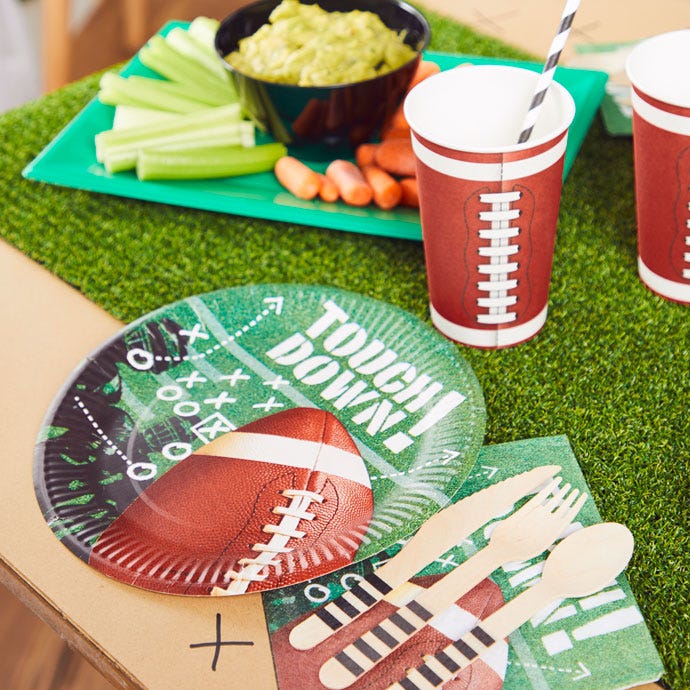Superbowl party table with green plates featuring 'touch down' phrase