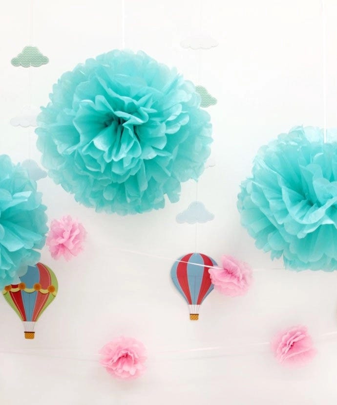 Turquoise paper pom pom decorations hanging from the ceiling