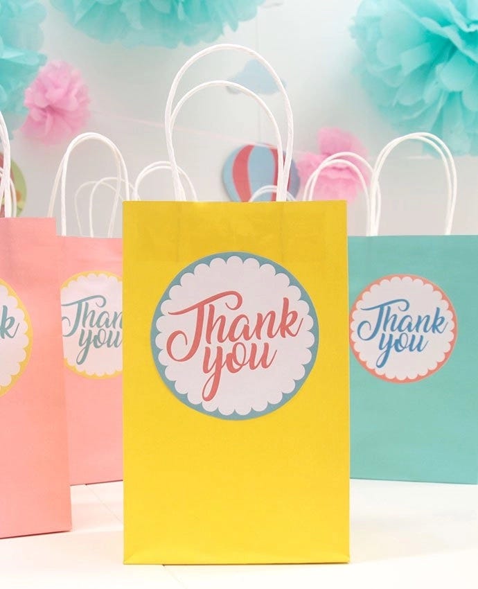 Multi-coloured party bags that say thank you on the front