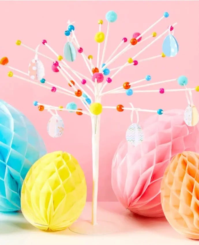 A decorated Easter tree surrounded by honeycomb decorations shaped like Easter eggs