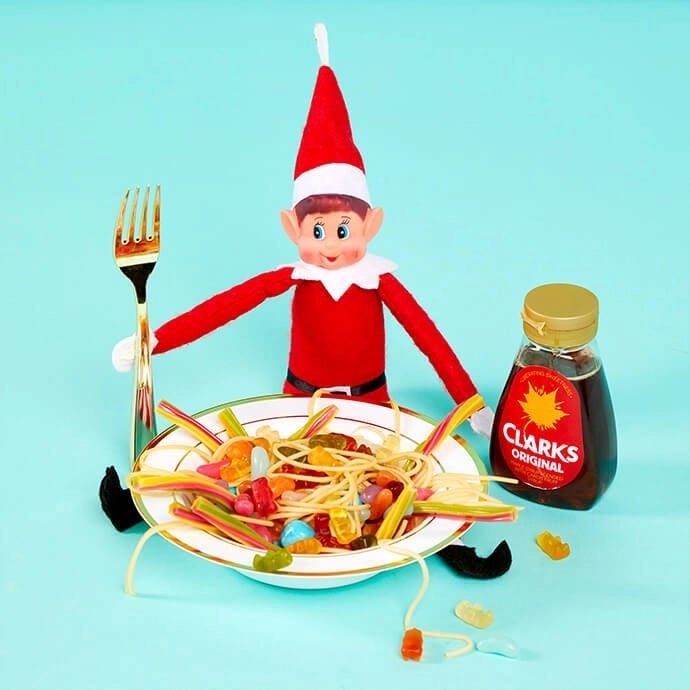 Elf on the Shelf eating a bowl of spaghetti and sweets