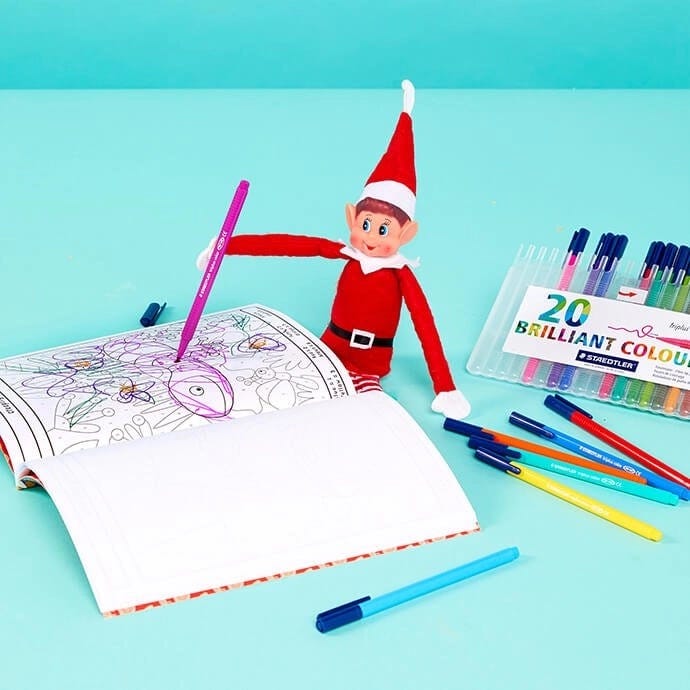 Elf on the Shelf doodling in a colouring book