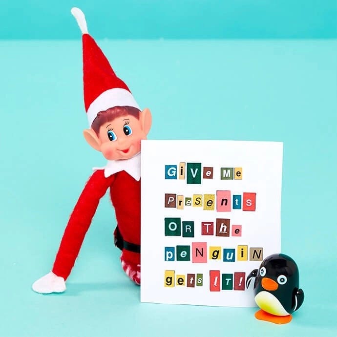 Elf on the Shelf with a ransom note that says "Give me presents or the penguin gets it"