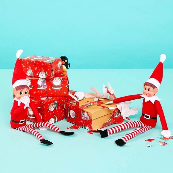 Elf on the Shelf unwrapping presents with another elf