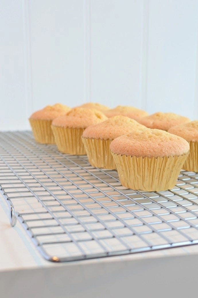 Freshly baked cupcakes on a wire cooling rack