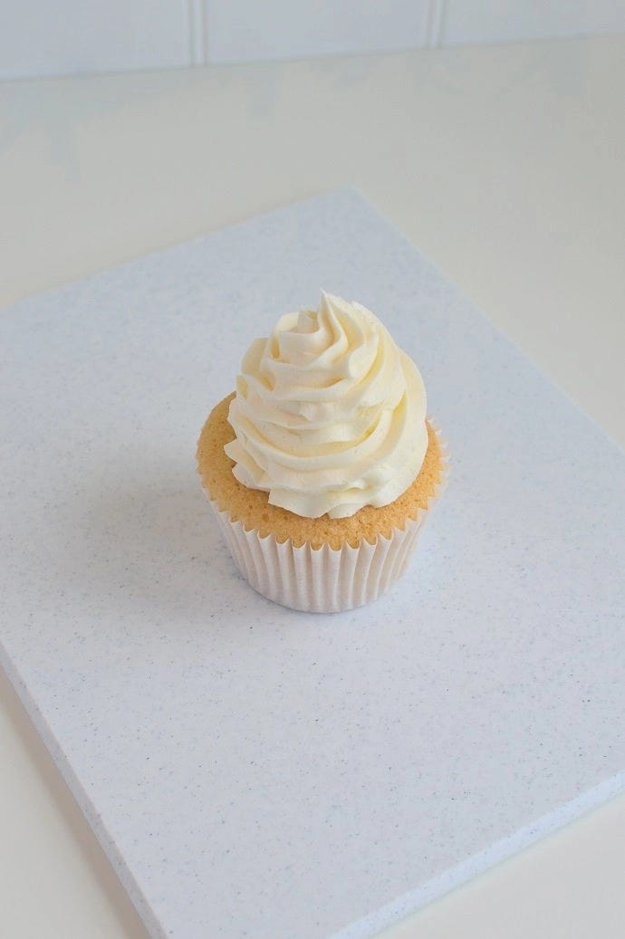A cupcake topped with vanilla icing