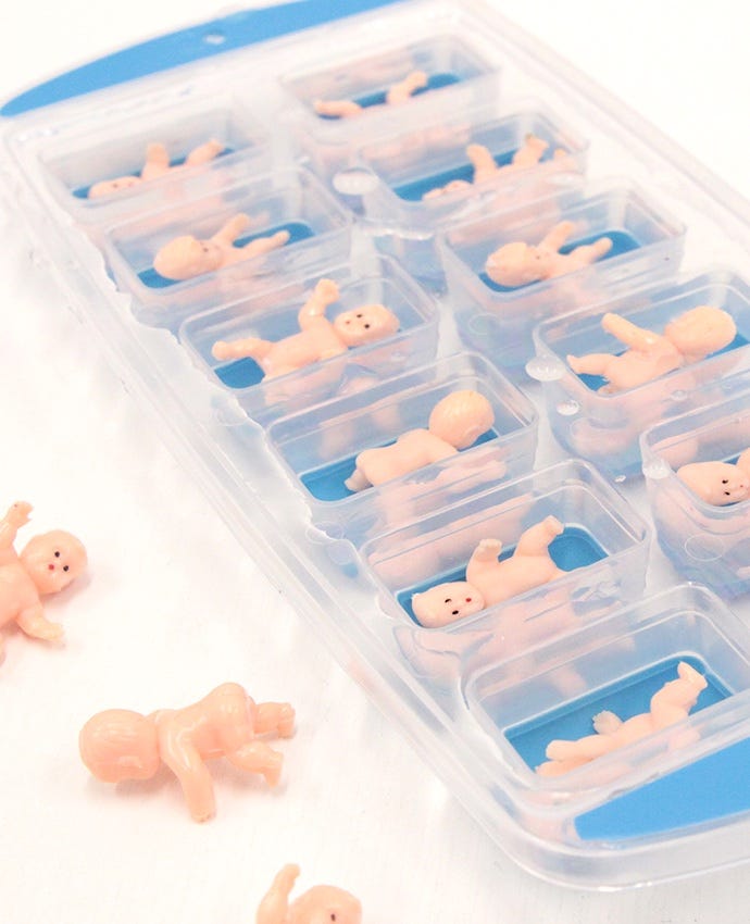 Mini plastic babies in an ice cube tray